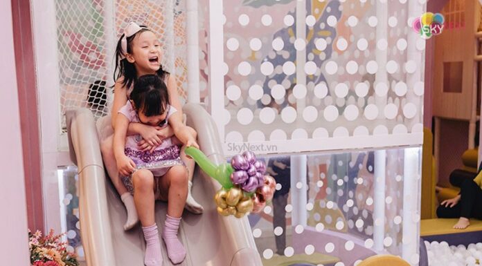 Lòng biết ơn là gì, Ý nghĩa và cách ứng dụng lòng biết ơn trong cuộc sống Hai bé gái ôm nhau trượt cầu trượt trong khu vui chơi, một bé cầm bó bong bóng hoa