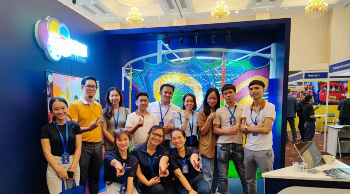 Nhóm người tham dự chụp ảnh trước gian hàng có mô hình lưới trò chơi màu sắc